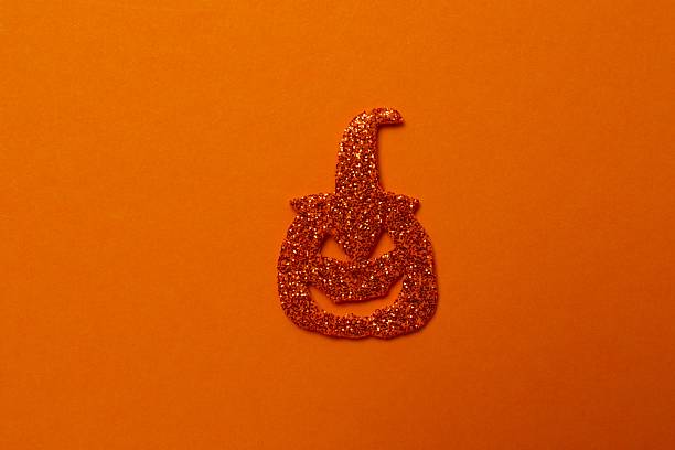 Halloween poscard with festive pumkin on orange background . Top view, space for text