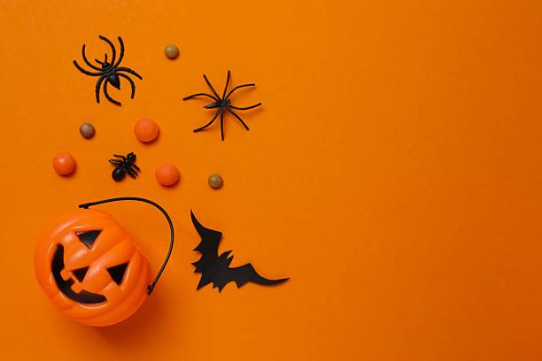 istock Halloween poscard with festive decorations on orange background . Top view, space for text 2253842185