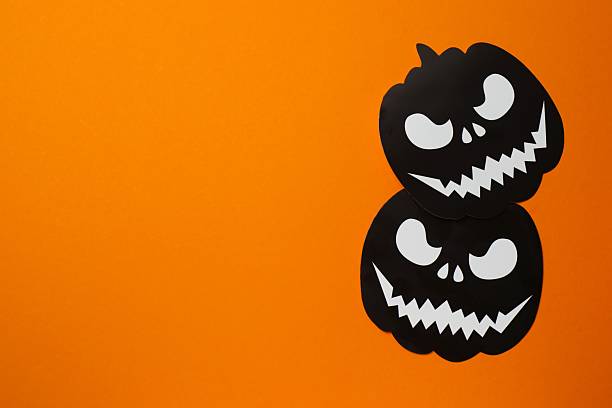 istock Halloween poscard with festive pumkins on orange background . Top view, space for text 2253842191