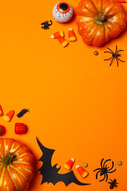 istock Different Halloween decorations including pumpkins, spiders, bats and candies on orange background 2253843164