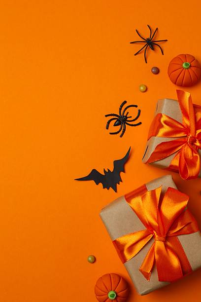 istock Halloween holiday decorations including gift box, pumpkins, spiders, bats on color background 2253843206