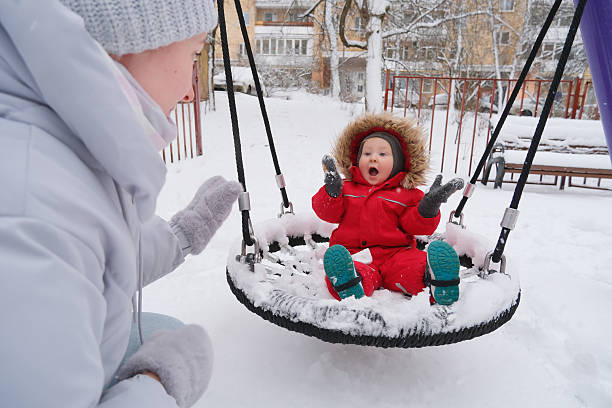 istock Child Enjoying a Swing Ride in Snowy Park 2253846061