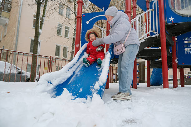 istock Child Sliding Down Snowy Playground with Joy 2253846283