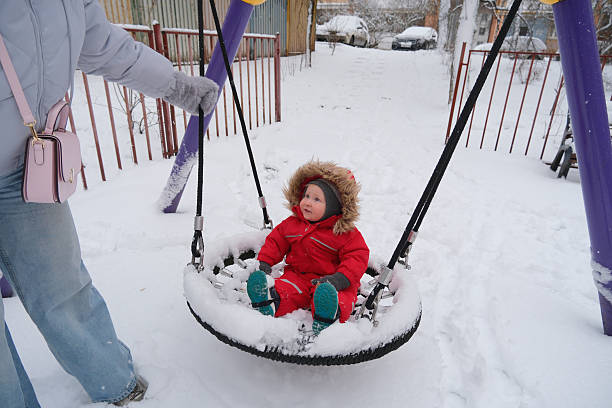 istock Child Enjoying a Snowy Day on a Swing 2253847521