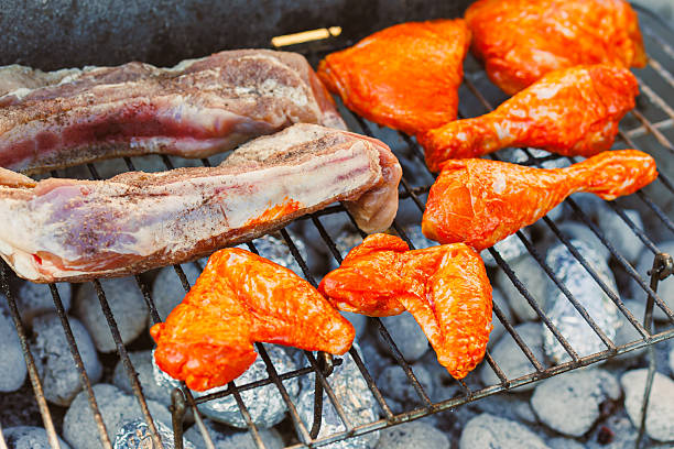 Indulge in a delectable selection of grilled meats, featuring succulent chicken drumsticks and juicy ribs, all expertly prepared on a sizzling BBQ grill to elevate your outdoor dining experience