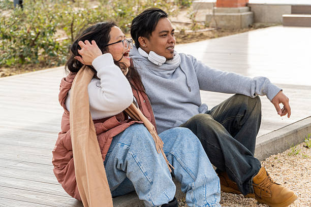 istock Asian couple laughing together outdoors on a sunny day 2253848932
