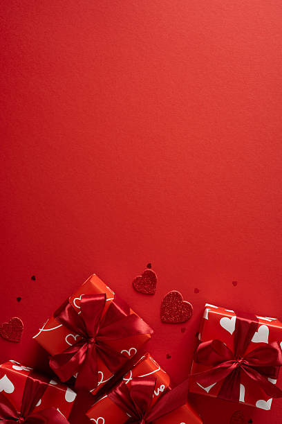 istock Red vertical gift boxes with white heart motifs on a bold backdrop evoke romance and celebration. Ideal scene for Valentineâs Day gifts, greeting moments, affection, and festive presentation 2253853702