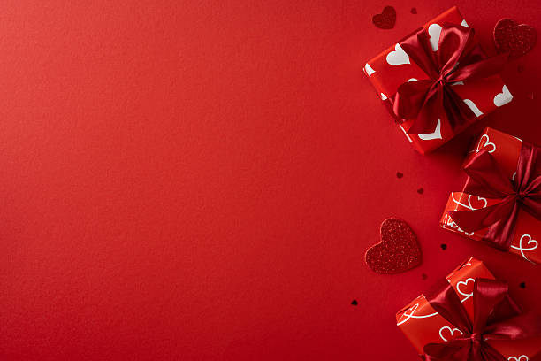 istock A vibrant red backdrop features wrapped gifts with heart patterns, ideal for Valentine celebration and greeting cards. The scene evokes romance, love, gift exchange, and festive mood 2253853707