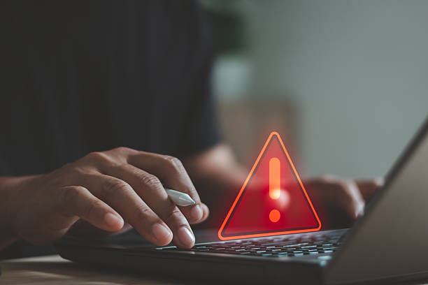 istock Cyber security warning concept with person typing on laptop, showing alert symbol and data risk notification. Cybersecurity, system error, data protection, hacking prevention, IT security services. 2253854432