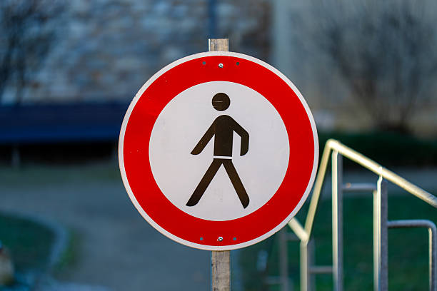 Round traffic sign displaying a prohibited pedestrian symbol