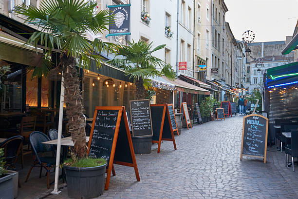 A charming picturesque sidewalk cafe on a street of shops in the historic medieval village town of Saint-Remy-de-Provence in the Provence Cote d'Azur region of Southern France.