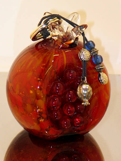 istock New Years talisman - a red glass pomegranate on a light 2253855874
