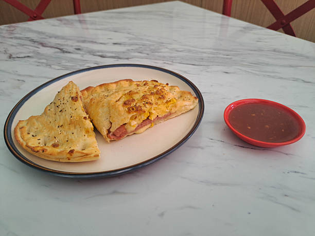 Delicious Calzone Smoked Beef Supreme with egg, mozzarella, cheese and smoked beef. Serving with spicy sauce. Food Menu.