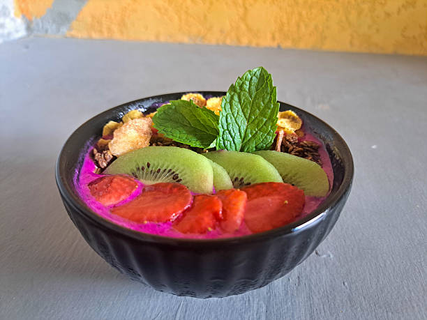 Fresh Dragon Smoothie Bowl with dragon fruit, banana, strawberry cornflakes cereal, granola, fresh milk and kiwi. Fruit Bar Menu.