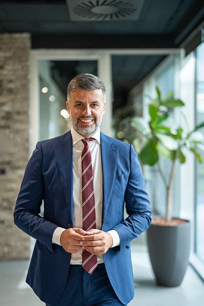 istock Smiling businessman standing in modern office hallway 2253862196