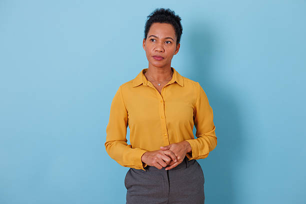istock Professional black woman standing on blue background, contemplating a complex business decision 2253863219