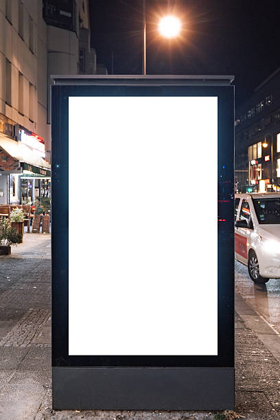 istock Vertical blank billboard mockup with white screen on urban street at night 2253865351
