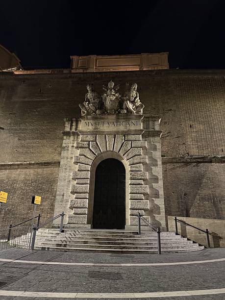 Vatican City - January 14th, 2025: A large door frames the exit to the Musei Vaticani, the Vatican Museum, a large collection of art, statuary, and other cultural artifacts held by the Pope at Vatican City.