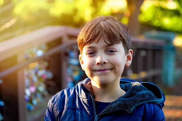 Smiling Little boy posing looking at the camera at a public park