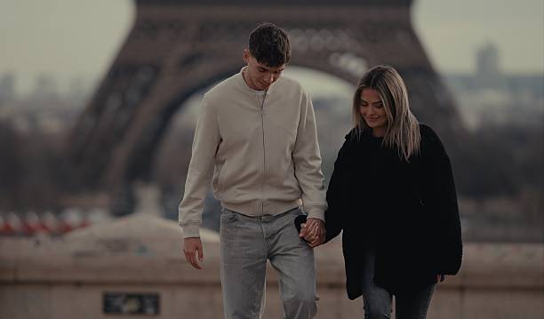 istock Young couple holding hands walking in Paris in front of Eiffel Tower 2253867240