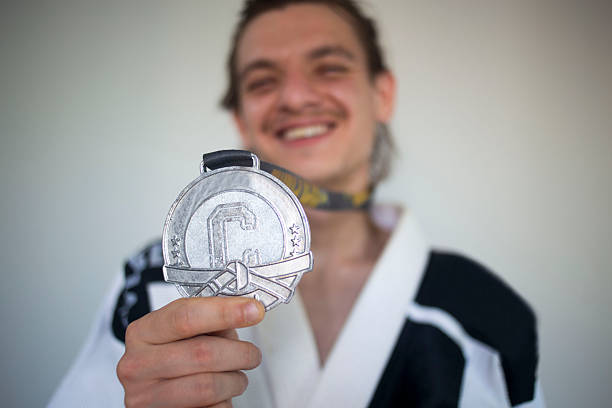 Happy jiu jitsu fighter showing up his medal