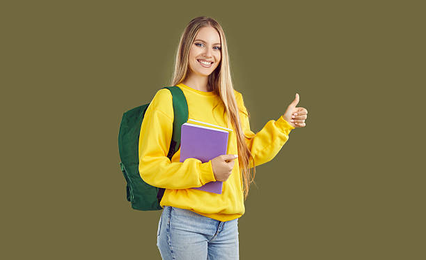 istock Happy successful university student holding notebook, giving thumbs up and smiling 2253871141