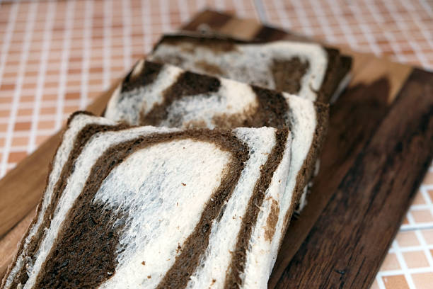 Bread slices with chocolate on wooden table. Rustic kitchen setting with freshly baked bread. Flat lay composition