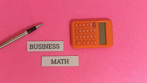 istock Business math concept with calculator pen on pink background 2253878332