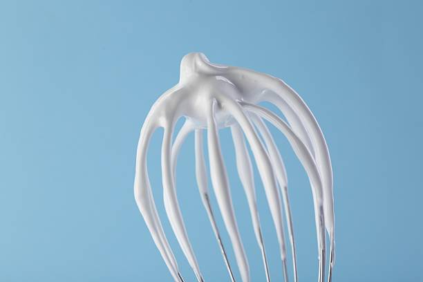 istock Whisk with whipped cream on light blue background, closeup 2253883751