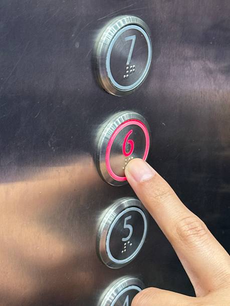 istock Close-up photo of a human finger pressing a modern elevator button with illuminated number and braille, showing accessibility design and everyday urban interaction. 2253884567