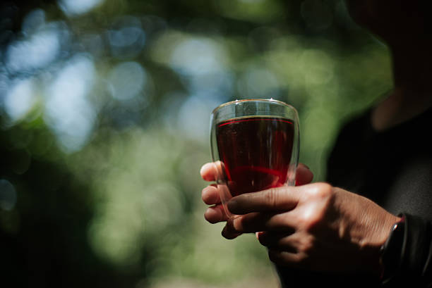 Close-up of a hand holding a hot tea cup in nature.