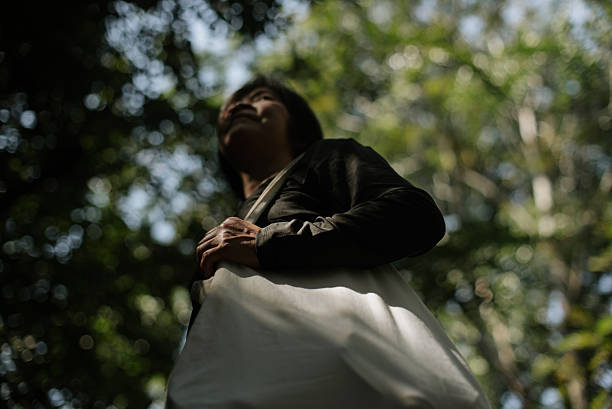 In-Silhouette of a mature woman carrying a reusable tote bag.