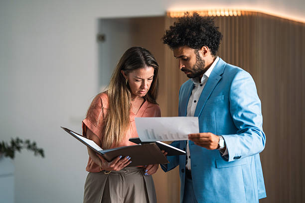 istock Caucasian Businesswoman and Middle Eastern Businessman Analyzing Documents in Modern Office 2253886027