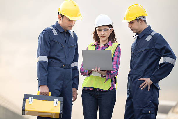istock Renewable energy maintenance. Engineer using digital tablet checking system of wind turbine at windmill field farm station. Wind turbine energy storage system. Workers meeting to check around the area 2253887191