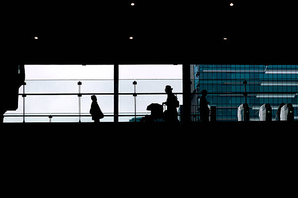istock Silhouette of people walking on elevated train station platform 2253887998