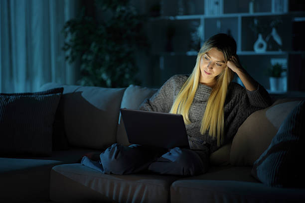 istock Relaxed woman at home in the night using laptop 2253888988
