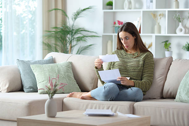 istock Perplexed woman receiving and checking letter 2253888989