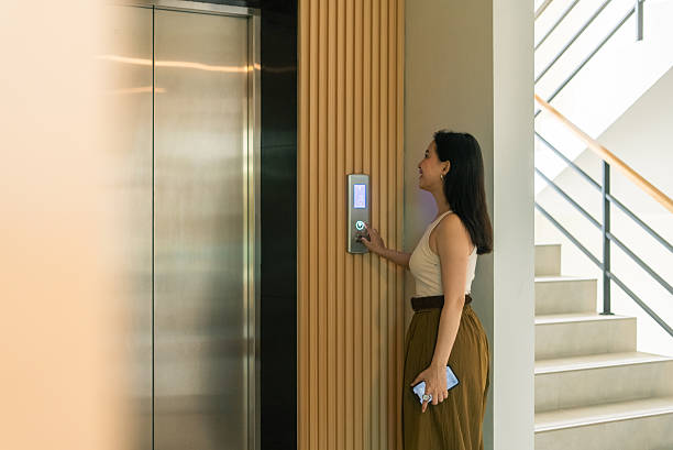 istock Woman pressing elevator button, waiting in modern building for daily commute 2253889060
