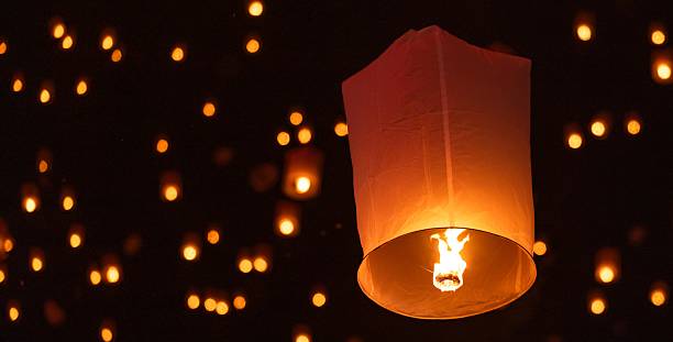 istock Sky lantern floating in the dark night sky, Tourist floating sky lanterns, Sky lanterns floating on night of Yi Peng, Loy Krathong Festival or Yi Peng Festival in Chiang Mai Thailand. 2253892319