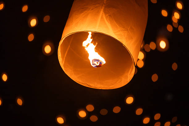 istock Sky lantern floating in the dark night sky, Tourist floating sky lanterns, Sky lanterns floating on night of Yi Peng, Loy Krathong Festival or Yi Peng Festival in Chiang Mai Thailand. 2253892396