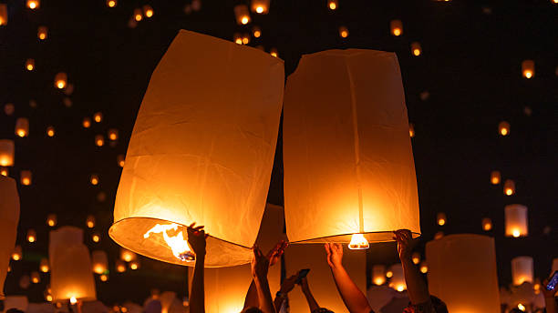 istock Sky lantern floating in the dark night sky, Tourist floating sky lanterns, Sky lanterns floating on night of Yi Peng, Loy Krathong Festival or Yi Peng Festival in Chiang Mai Thailand. 2253892413