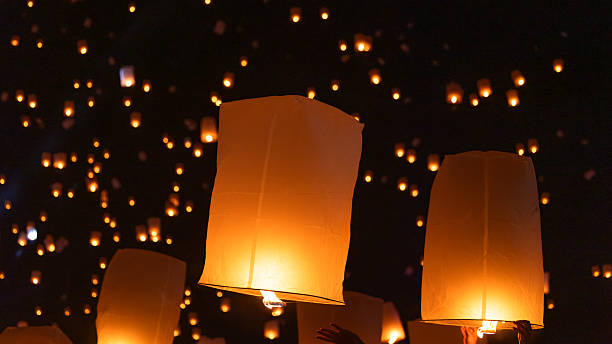 istock Sky lantern floating in the dark night sky, Tourist floating sky lanterns, Sky lanterns floating on night of Yi Peng, Loy Krathong Festival or Yi Peng Festival in Chiang Mai Thailand. 2253892421