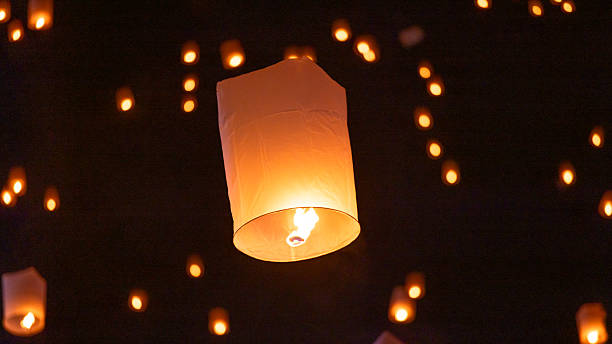 istock Sky lantern floating in the dark night sky, Tourist floating sky lanterns, Sky lanterns floating on night of Yi Peng, Loy Krathong Festival or Yi Peng Festival in Chiang Mai Thailand. 2253892440