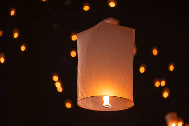 istock Sky lantern floating in the dark night sky, Tourist floating sky lanterns, Sky lanterns floating on night of Yi Peng, Loy Krathong Festival or Yi Peng Festival in Chiang Mai Thailand. 2253892449
