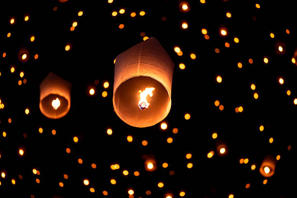 istock Sky lantern floating in the dark night sky, Tourist floating sky lanterns, Sky lanterns floating on night of Yi Peng, Loy Krathong Festival or Yi Peng Festival in Chiang Mai Thailand. 2253892480