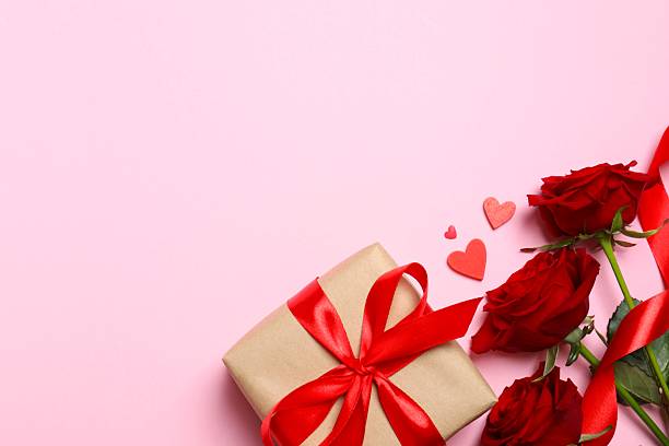 istock Beautiful red roses, gift box and hearts on pink background 2253893650