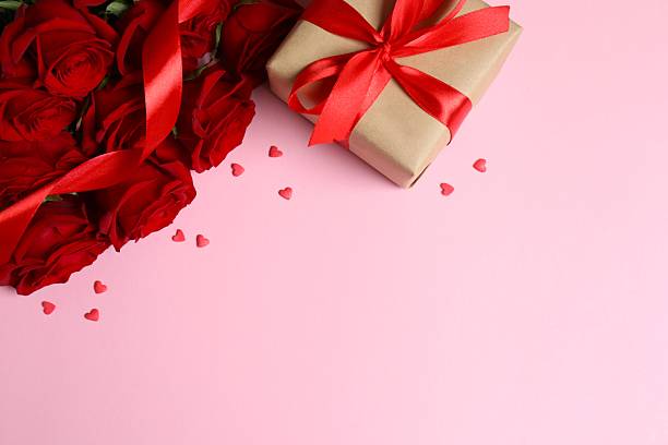 istock Beautiful red roses, gift box and hearts on pink background 2253893723