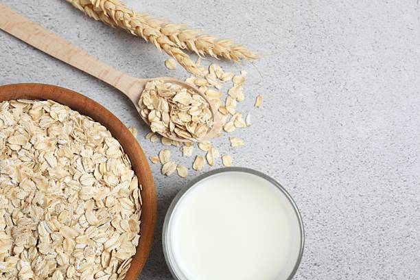 istock Composition with oatmeal flakes on gray  background. Cooking breakfast 2253894697