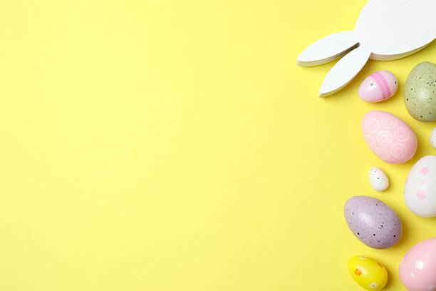 istock Happy Easter. Colorful eggs with bunny ears on color background, space for text or advertising 2253895021