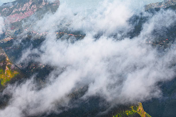 Clouds over mountain valley with distant village stock photo